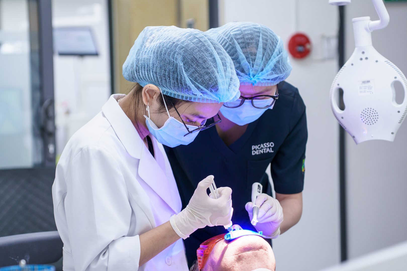 Dentist applying teeth whitening gel at Picasso Dental Da Nang Hoàng Diệu